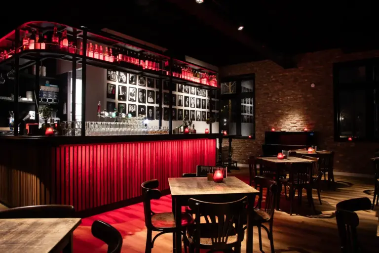 De foyer van Comedytrain, met de rode bar en tafels voor het diner